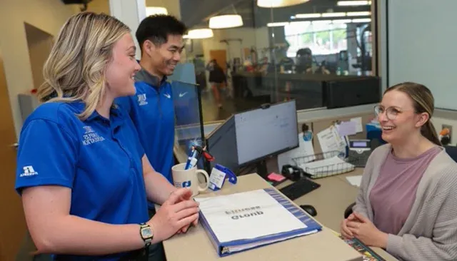 student and staff talking at welcome desk